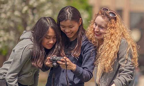 three Carroll University students looking at a camera.